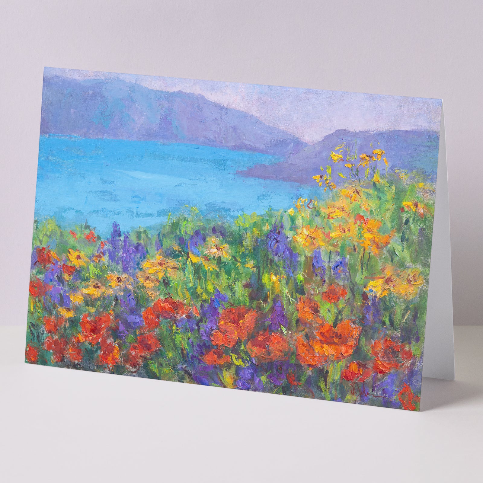 Fine art greeting card set 5x7, five cards displayed on background, including orange California poppies and other wildflowers, meadows, hills, lake, all based on original landscape oil paintings by Oksana Johnson. Yellow flowers, green grass, blue water, white clouds.