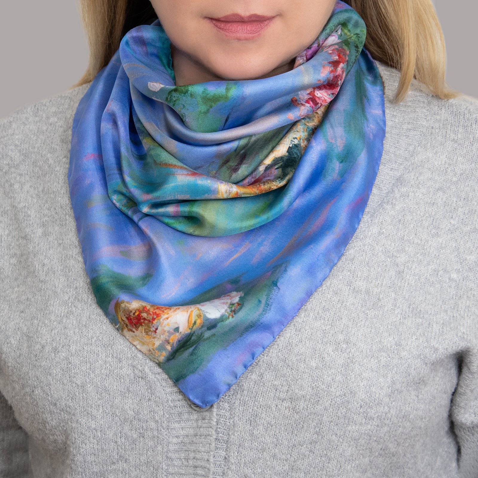 Square silk scarf with floating waterlilies in pink, yellow, and white on blue water and green lily pads, based on impressionist painting by Oksana Johnson.