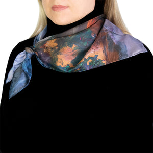 Colorful Twilight Reflections scarf worn by model in black turtleneck, tied on the side. 