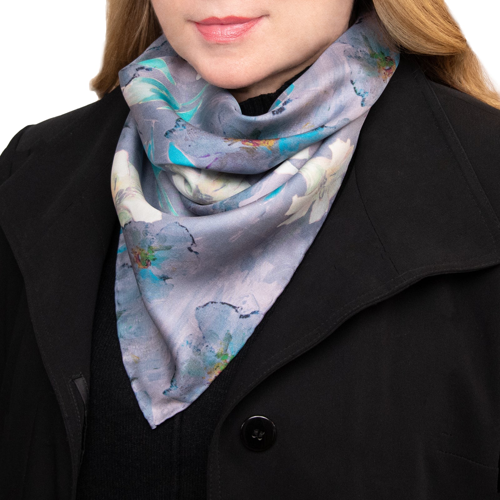 Woman wearing a colorful white lilies scarf and a black coat, hand hemmed.