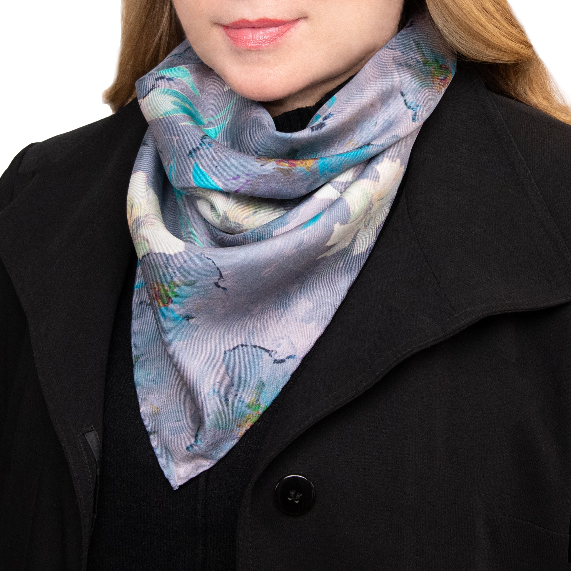 Woman wearing a colorful white lilies scarf and a black coat, hand hemmed.