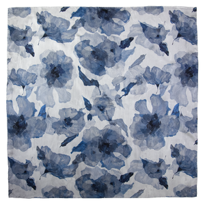 Square silk scarf with overlapping floral images in blue and light tones, with hand-hemmed edges. 