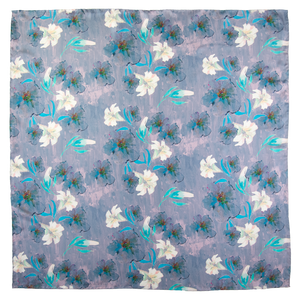 Square scarf with floral pattern including white lilies, with blue, and purple elements, hand hemmed edges. 
