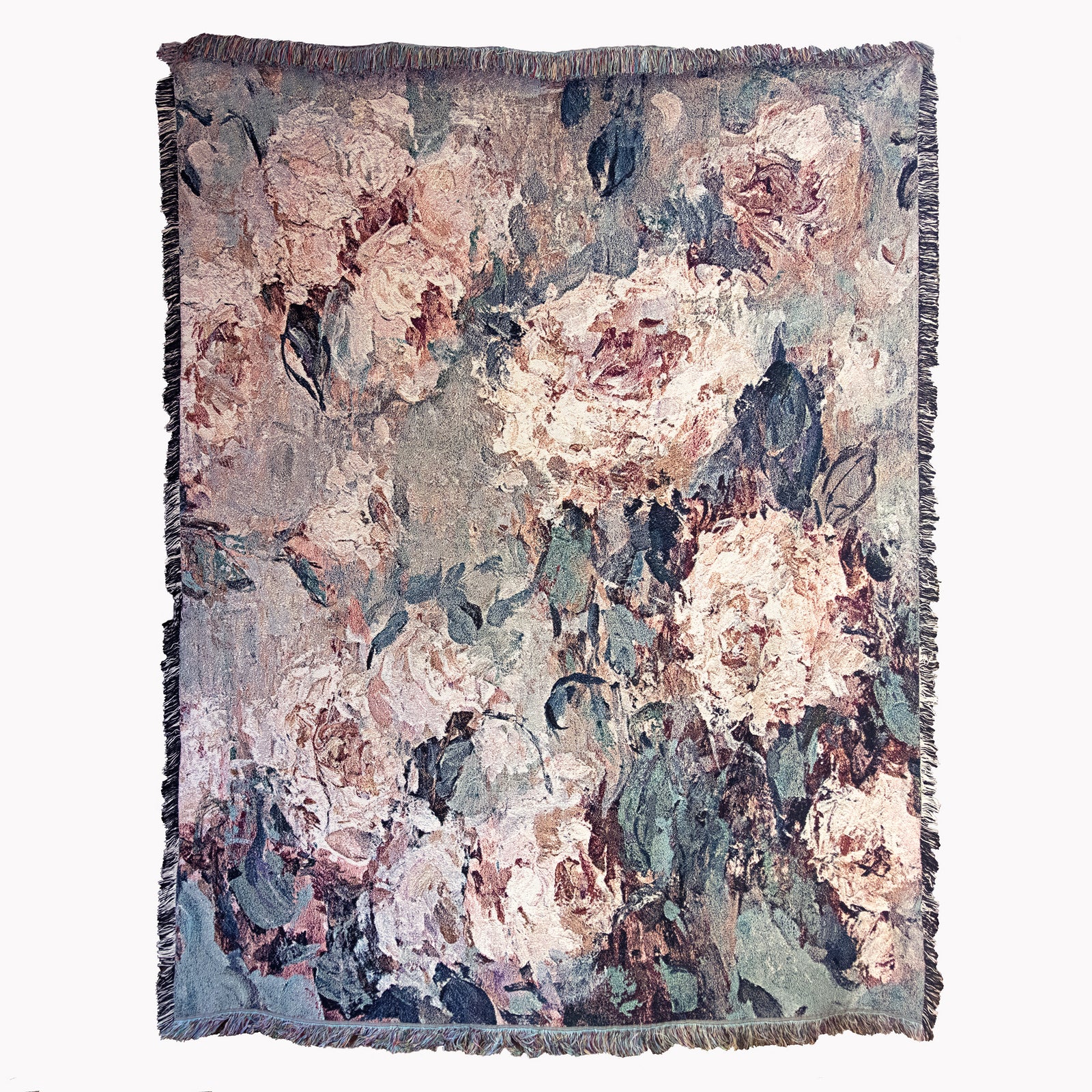 Floral patterned decorative woven blanket with impressionist design of roses, draped over a couch, in front of stairs.